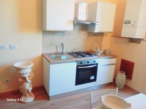 a small kitchen with a stove and a sink at Templum Iovis-Front of port in Civitavecchia