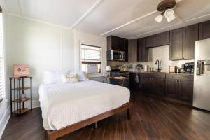 a bedroom with a white bed and a kitchen at Depot Village in Gainesville