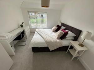 a bedroom with a bed with a desk and a window at Spacious and stylish 3-bed home ideal for families in Stockton-on-Tees