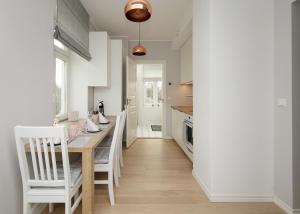 a kitchen and dining room with a table and chairs at Kalamehe Apartment 4 near City center in Pärnu