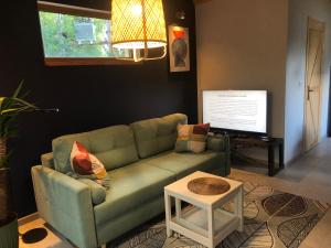 a living room with a green couch and a table at PIEPRZ i Wanilia - Kopalino dom z widokiem na las 3 pokoje taras parking WiFi - Pieprz in Kopalino