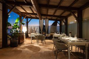 a dining room with tables and chairs and windows at Relais Torre Mozza - Dimora d' Epoca in Follonica