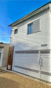 um edifício branco com uma porta de garagem e uma janela em Casa Ampla - Ótima Localização em Piracicaba