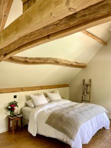 a bedroom with a large bed with wooden beams at Edda Country House - Val de Loire in Onzain +49 photos