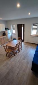 a large room with a wooden table and chairs at Apartamenty Koło Brzegu in Gąski