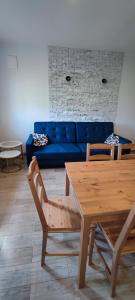 a living room with a blue couch and a table at Apartamenty Koło Brzegu in Gąski