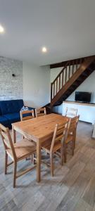 a wooden table and chairs in a living room at Apartamenty Koło Brzegu in Gąski