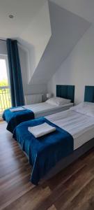 3 Betten in einem blau-weißen Zimmer in der Unterkunft Apartamenty Koło Brzegu in Gąski