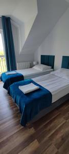 2 Betten in einem blau-weißen Zimmer in der Unterkunft Apartamenty Koło Brzegu in Gąski