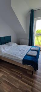 a bed in a room with a large window at Apartamenty Koło Brzegu in Gąski