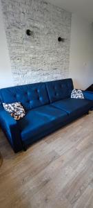 - un canapé bleu dans le salon dans l'établissement Apartamenty Koło Brzegu, à Gąski