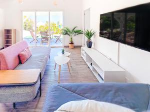sala de estar con sofá y TV en Villa Romane private pool breathtaking sea view, en Anse Marcel 