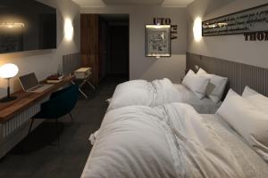 a hotel room with two beds and a desk at L Boutique Hotel in Angra do Heroísmo