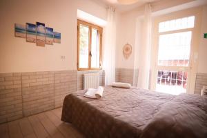 una camera da letto con un letto e asciugamani di Holidayhouse Ostia - Libeccio a Lido di Ostia