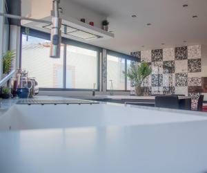 une cuisine avec un comptoir blanc et quelques plantes dans l'établissement Loft de 2 Suites, Jacuzzi, Sauna et Massage, à Blagnac