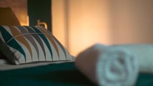uma almofada sentada em cima de uma cama em Loft de 2 Suites, Jacuzzi, Sauna et Massage em Blagnac