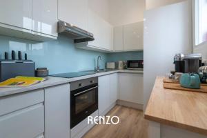 una cucina con armadi bianchi e piano cottura di Immaculate 2-Bed Apartment in Newark on-Trent by Renzo, Free Parking and Wi-Fi! a Newark upon Trent