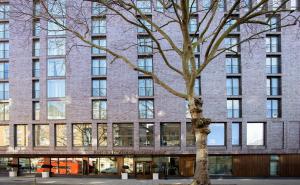 a large brick building with a tree in front of it at H10 London Waterloo in London