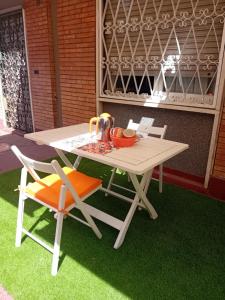 a picnic table and two chairs on the grass at casArancia 72 in Rome