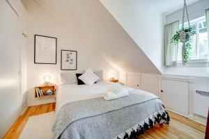ein weißes Schlafzimmer mit einem großen Bett im Dachgeschoss in der Unterkunft La Casa del Plage - Spa privé et Hamak in Sainte-Lucie-de-Doncaster