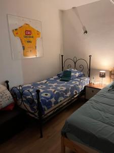 Schlafzimmer mit einem Bett mit einer blauen und weißen Bettdecke in der Unterkunft Kamer met kitchenette in Bédoin
