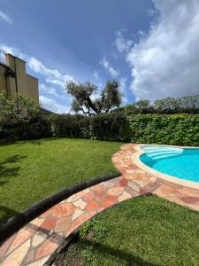 un patio trasero con piscina y césped en Villa Vie En Rose en Sorrento