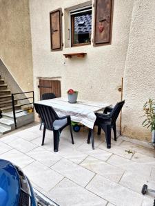 una mesa y sillas en un patio en Maison de 3 chambres avec terrasse et wifi a Faverges Seythenex en Vésonne