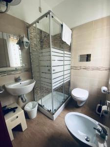 a bathroom with a shower and a toilet and a sink at Hotel Eva La Romantica in Moneglia