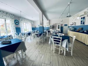 a restaurant with blue tables and white chairs at Hotel Eva La Romantica in Moneglia