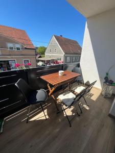 einen Balkon mit einem Holztisch und Stühlen darauf in der Unterkunft Apartman Sandra in Nova Gradiška