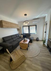 uma sala de estar com um sofá e uma mesa em Apartman Sandra em Nova Gradiska