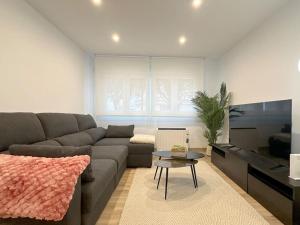 uma sala de estar com um sofá e uma mesa em Apartamento reformado en Santoña em Santoña