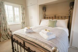 1 dormitorio con 1 cama con toallas en Well decorated & traditional cottage on Wales England border - sleeps 7 en Rossett