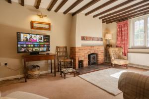 sala de estar con chimenea y TV en Well decorated & traditional cottage on Wales England border - sleeps 7 en Rossett