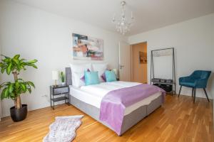 um quarto com uma cama grande e uma cadeira azul em Special EiNSTEiN I Apartment Basel, Messe Kleinbasel 10-STAR em Basileia