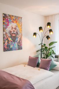 um quarto com uma cama com um quadro na parede em Special EiNSTEiN I Apartment Basel, Messe Kleinbasel 10-STAR em Basileia