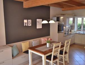 a kitchen and dining room with a table and chairs at Alte Schule 4 in Staberdorf