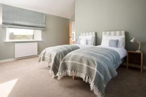 a bedroom with two beds and a window at Wild Rye in Bamburgh