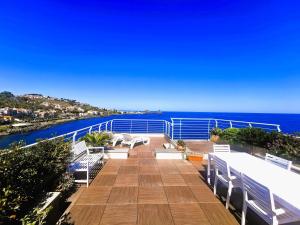un balcón con bancos blancos y el océano en The sea you can feel en Aci Castello