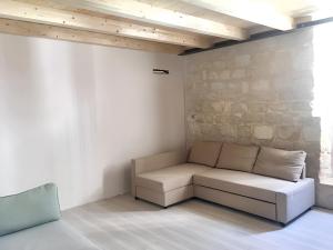 een bank in een kamer met een stenen muur bij One bedroom house at Pozzallo 500 m away from the beach with balcony in Pozzallo
