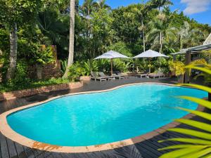 a swimming pool in a resort with chairs and umbrellas at Leopard Tree Lodge in St Lucia