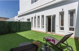 a backyard with a green lawn and a white building at Ático Rianal in Jerez de la Frontera
