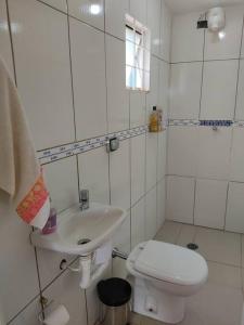 een witte badkamer met een toilet en een wastafel bij Sítio Amoreira próximo à divisa com Atibaia in Mairiporã