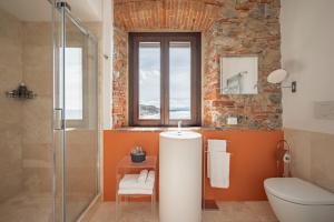 uma casa de banho com um WC e uma cabina de duche em vidro. em Relais Torre Mozza - Dimora d' Epoca em Follonica