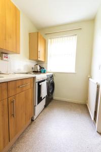 een keuken met een wasmachine en droger en een raam bij Convenient 1Bed Apt Close to Transport Links in Manchester