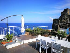 balcón con mesa, sillas y vistas al océano en The sea you can feel en Aci Castello