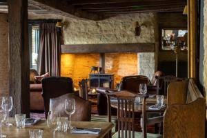 a restaurant with tables and chairs and a fireplace at The Harcourt Arms in Stanton Harcourt