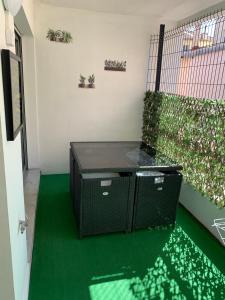 a room with a green floor and a fence with plants at Appartement Nice Magnan in Nice