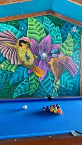 two birds sitting on top of a pool table at CasaBosque in Tarapoto