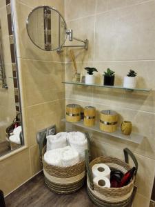 a bathroom with two baskets of towels and a mirror at Apartament Brzozowa 5minut Krupówki in Zakopane